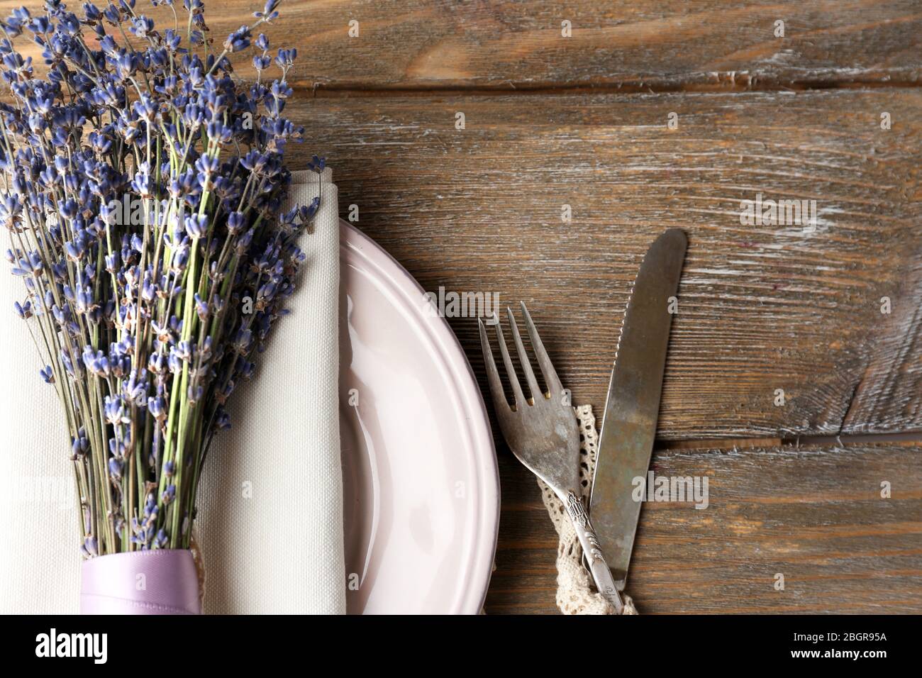 Tavolo da pranzo impostazione con fiori di lavanda sul tavolo di legno sfondo Foto Stock