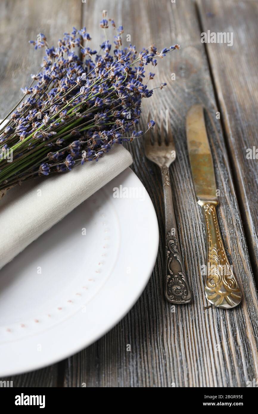 Tavolo da pranzo impostazione con fiori di lavanda sul tavolo di legno sfondo Foto Stock