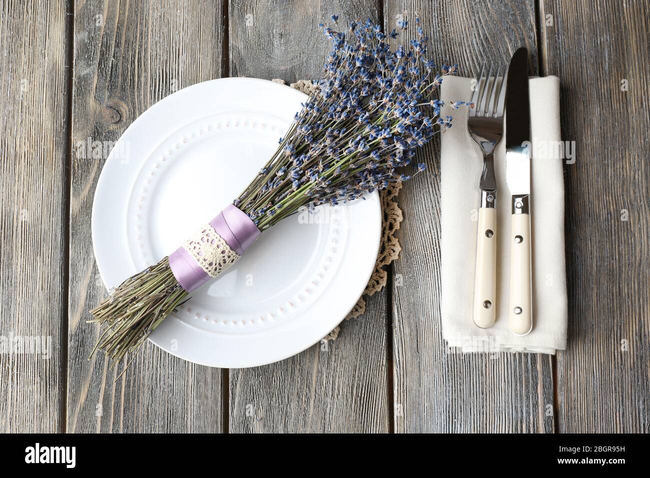 Tavolo da pranzo impostazione con fiori di lavanda sul tavolo di legno sfondo Foto Stock