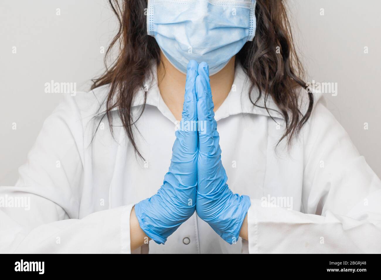 Le donne mano in guanti blu medico mostrano il segno Namaste o Namaskar. Stop SARSCoV, virus 2020, virus cinese COVID-19. Concetto di protezione contro l'HIV Foto Stock