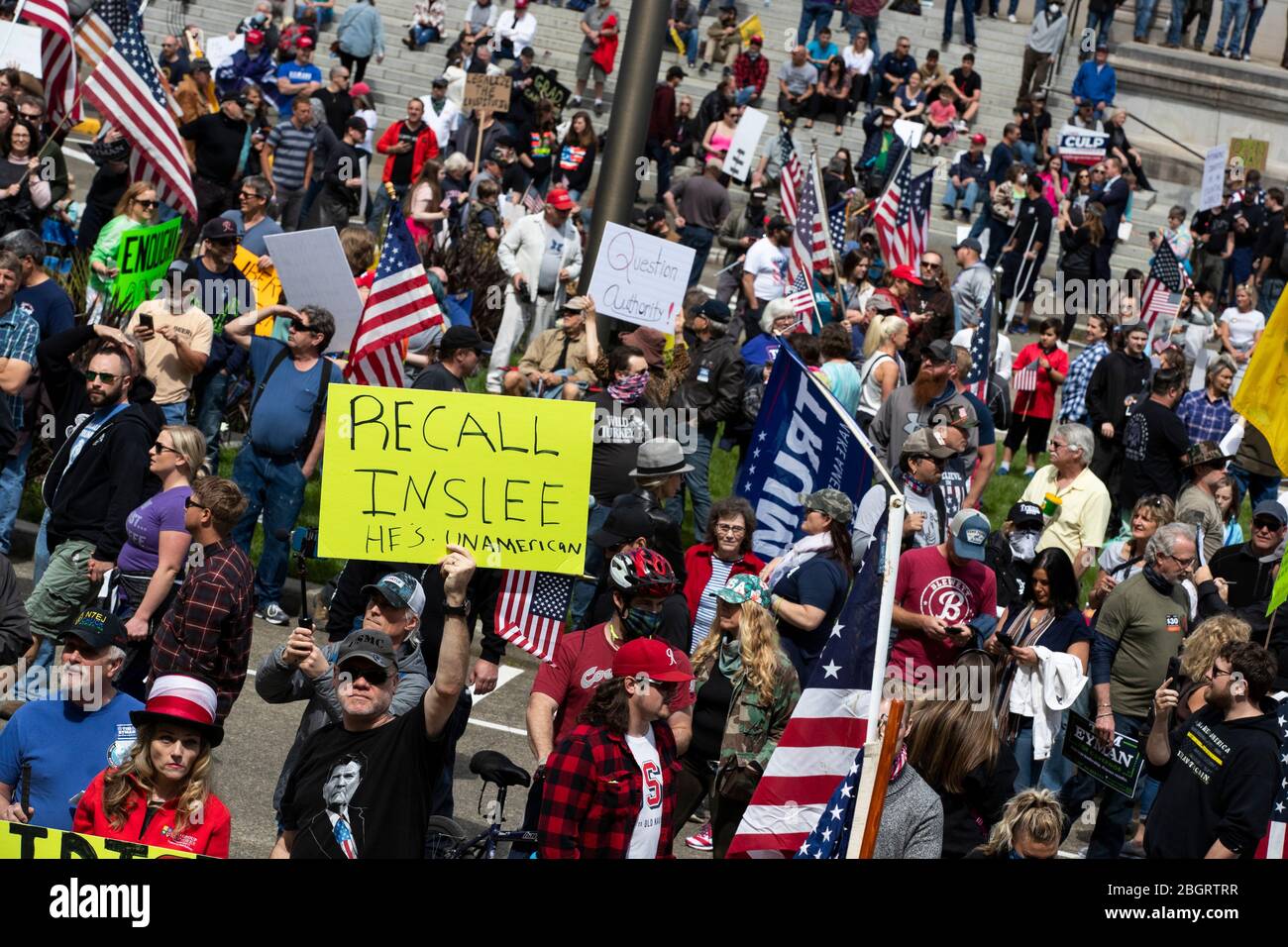 Un uomo ha un segnale che dice: "Recall Inslee", per una protesta contro le restrizioni sul soggiorno a casa durante la pandemia COVID-19 presso lo Stato di Washington capita Foto Stock