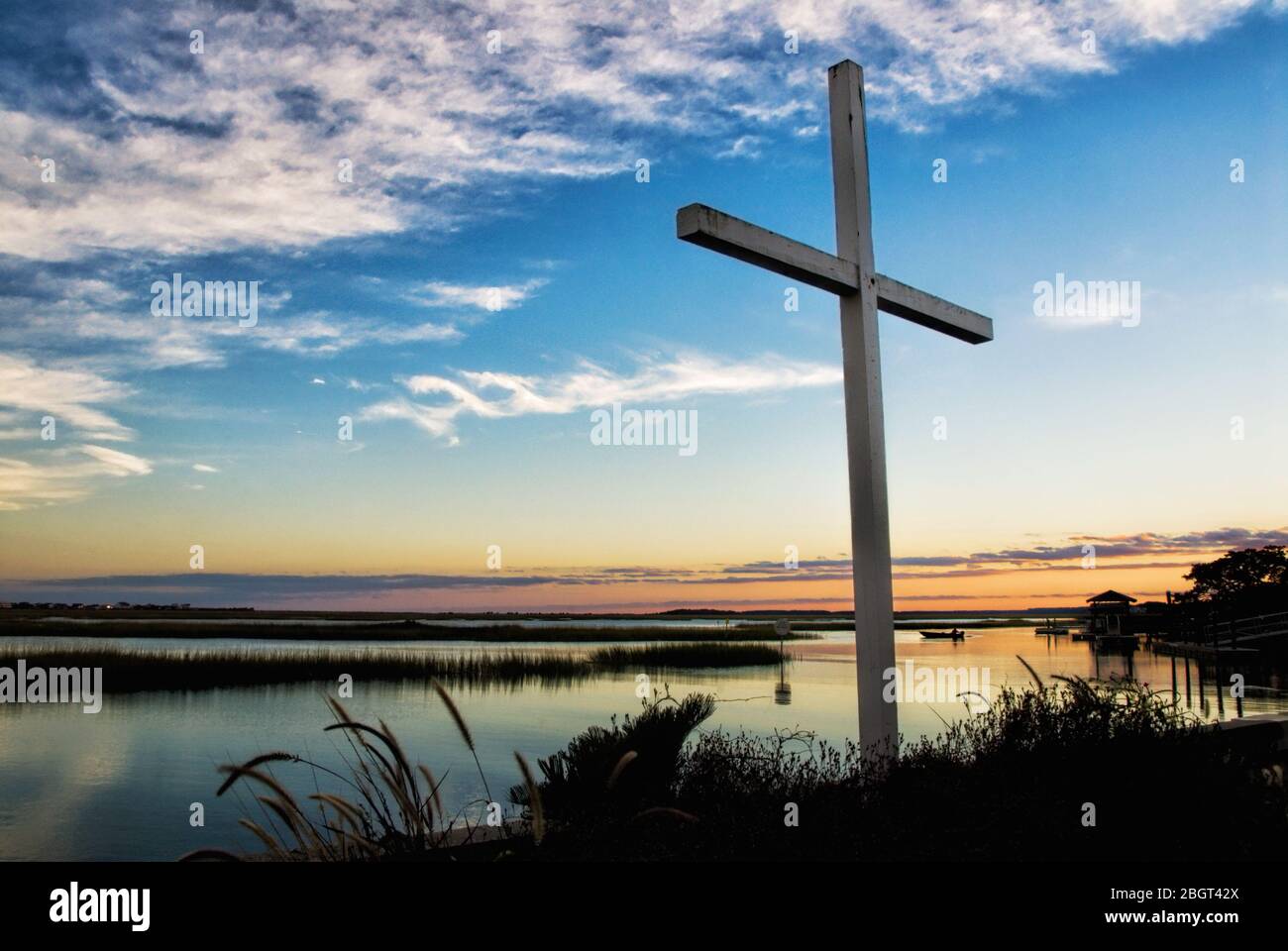Tramonto su una croce di legno al bordo delle acque di una palude di acqua salata in Murrells Inlet South Carolina Foto Stock