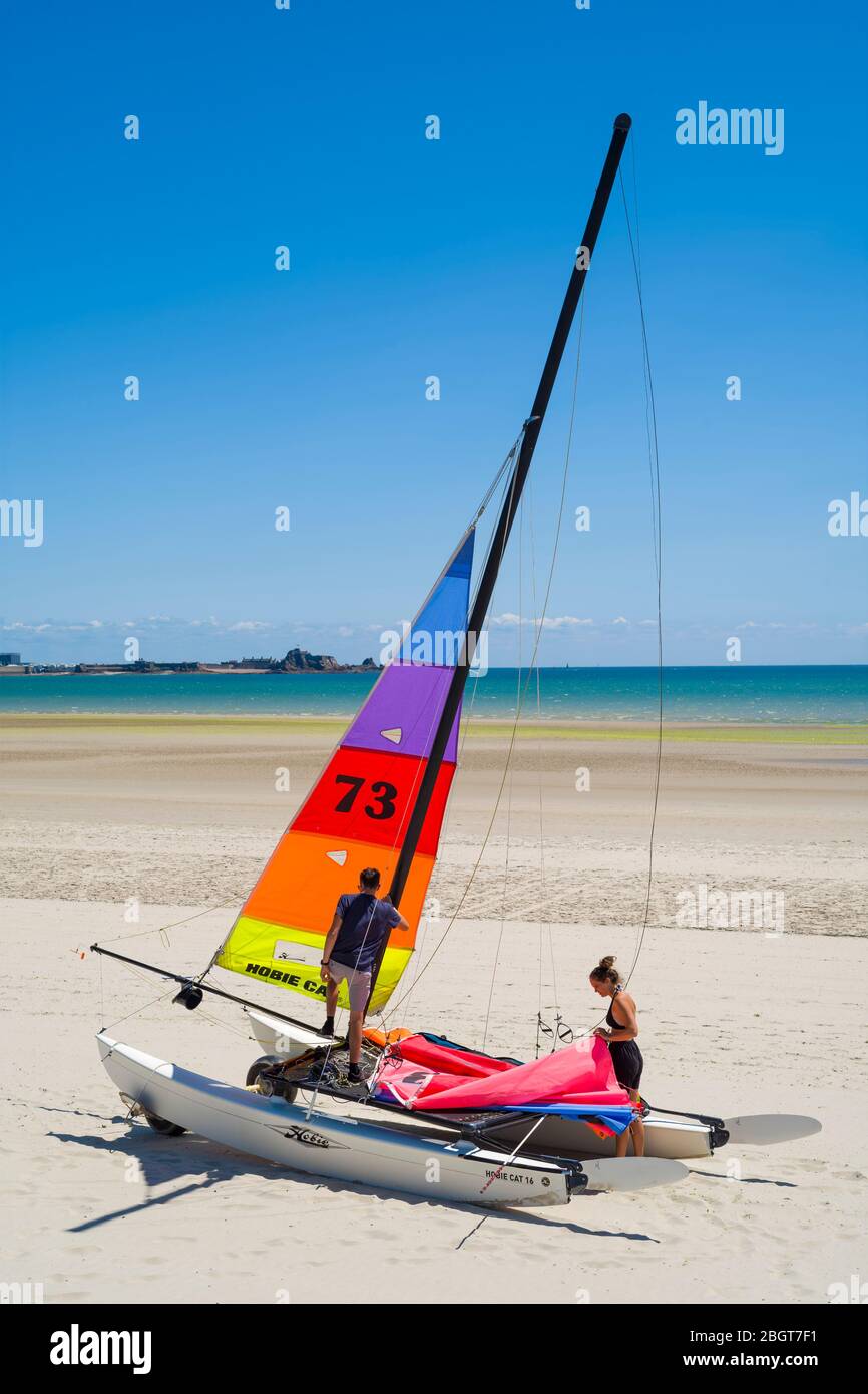 I giovani preparano il catamarano Hobie Cat sulla spiaggia sabbiosa di St Aubin, Jersey, Channel Isles Foto Stock