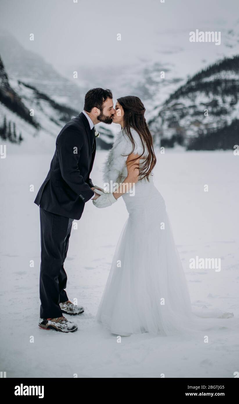 Coppia appena sposata bacio condivisione sul lago congelato Louise canada Foto Stock