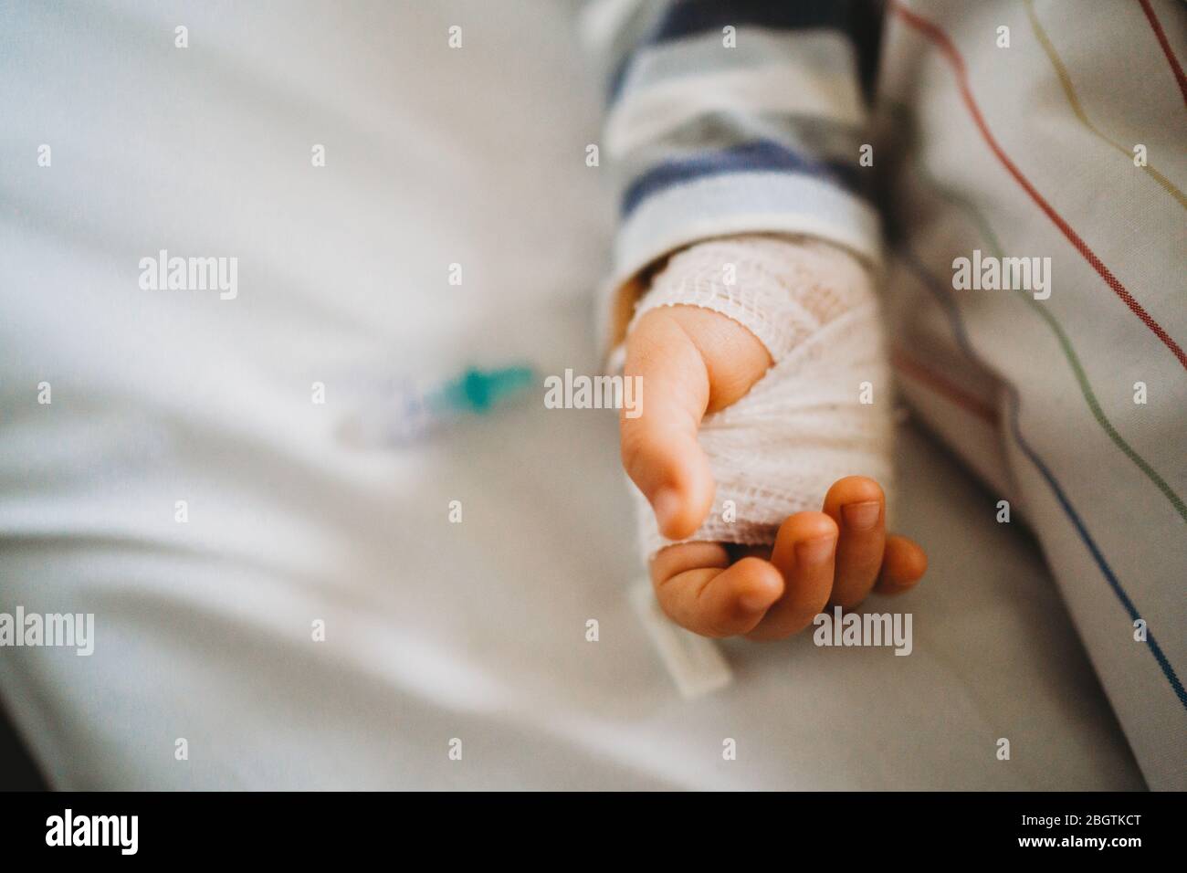 Bambino mano con IV malato in ospedale con un virus coronavirus Foto Stock