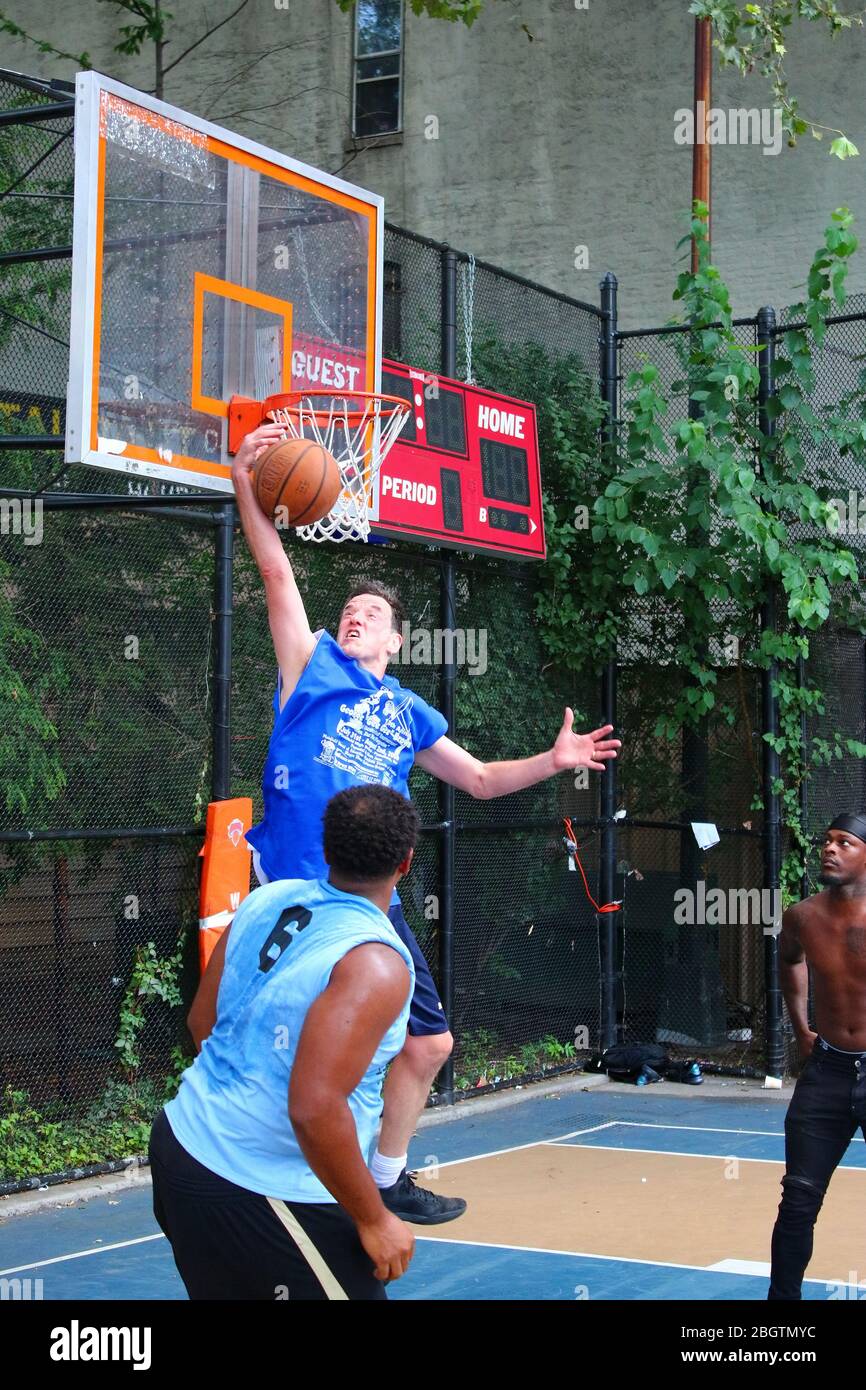 Giocatori dilettanti che si scrambling per la palla sotto il tabellone mentre giocano a basket in 'The Cage', West 4th Street Courts, Manhattan il 29 LUGLIO 2019 i Foto Stock