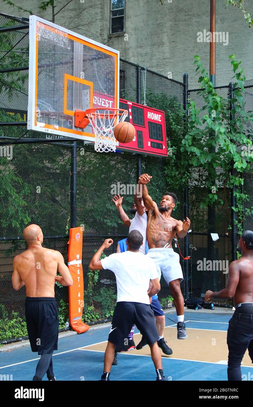 Giocatori dilettanti che si scrambling per la palla sotto il tabellone mentre giocano a basket in 'The Cage', West 4th Street Courts, Manhattan il 29 LUGLIO 2019 i Foto Stock