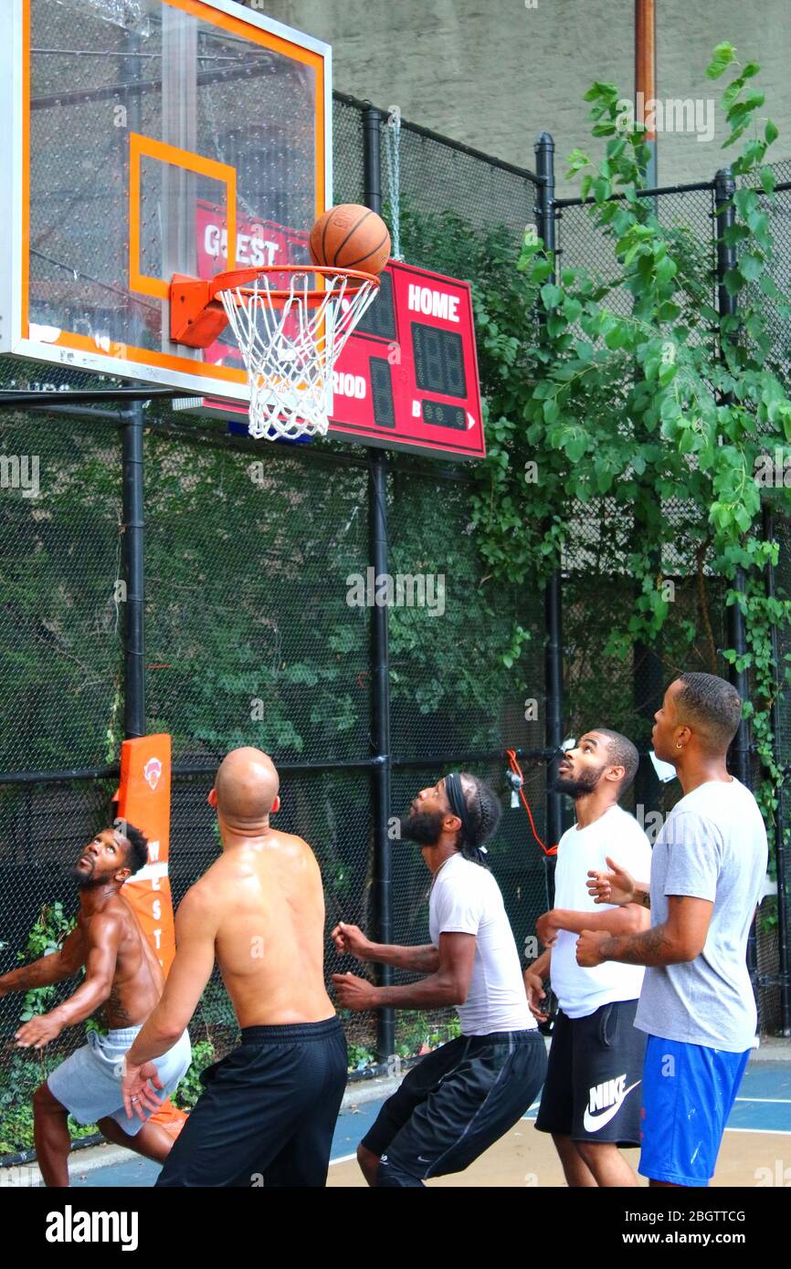 Giocatori dilettanti che si scrambling per la palla sotto il tabellone mentre giocano a basket in 'The Cage', West 4th Street Courts, Manhattan il 29 LUGLIO 2019 i Foto Stock