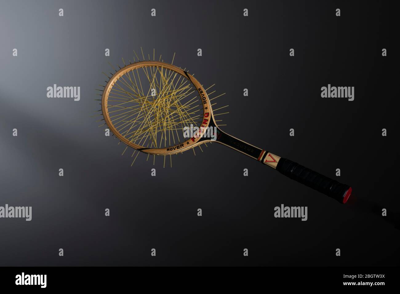 Racchetta da tennis in legno con corde di spaghetti; immagine alimentare concettuale Foto Stock