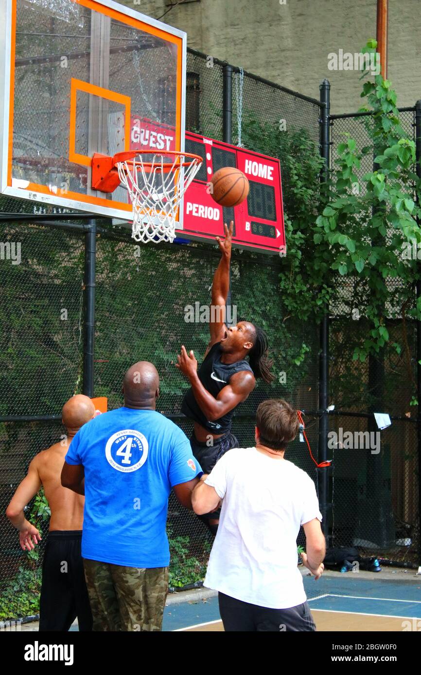 Giocatori dilettanti che si scrambling per la palla sotto il tabellone mentre giocano a basket in 'The Cage', West 4th Street Courts, Manhattan il 29 LUGLIO 2019 i Foto Stock