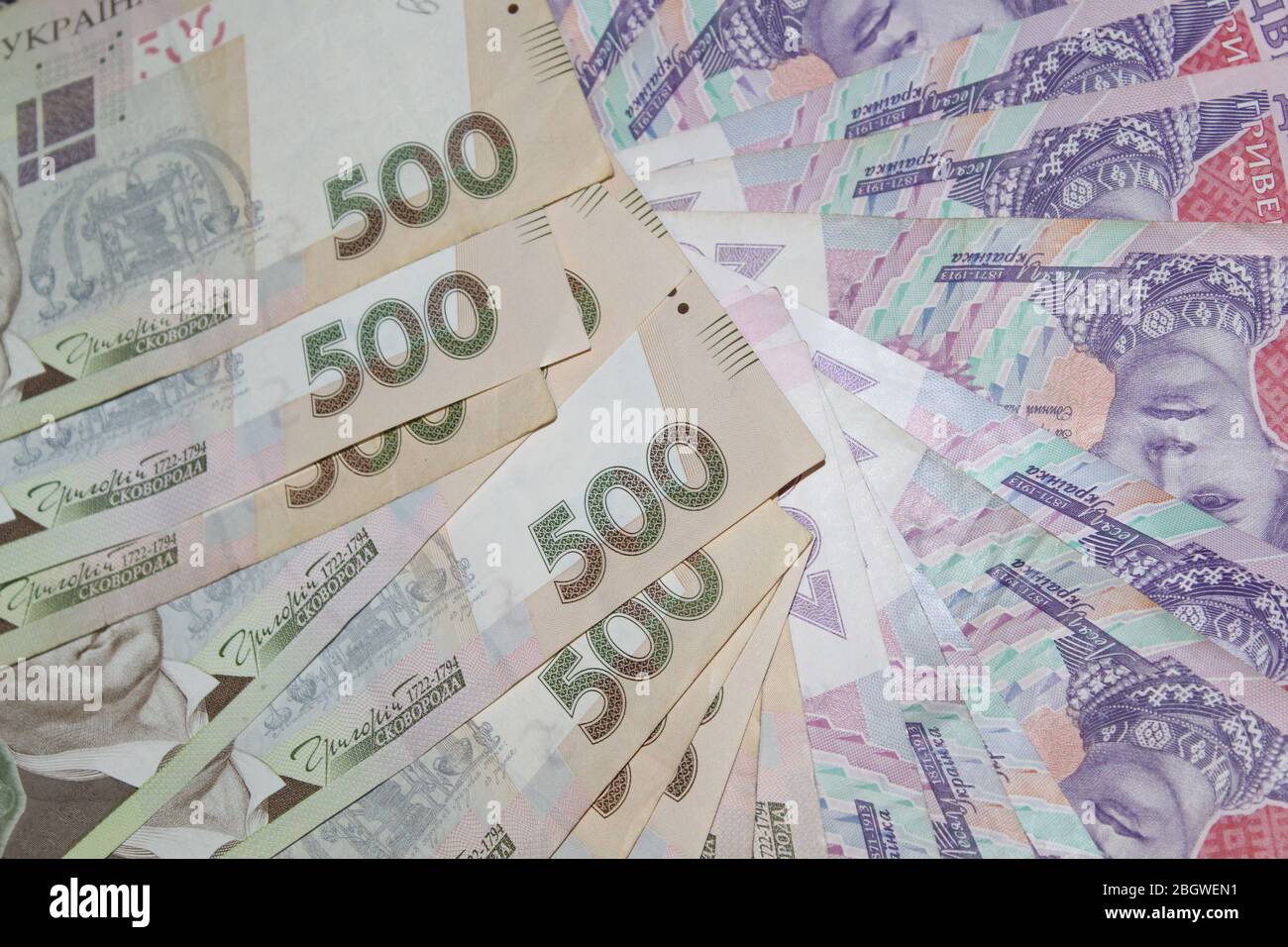 Un sacco di soldi sparsi su un tavolo bianco Foto Stock