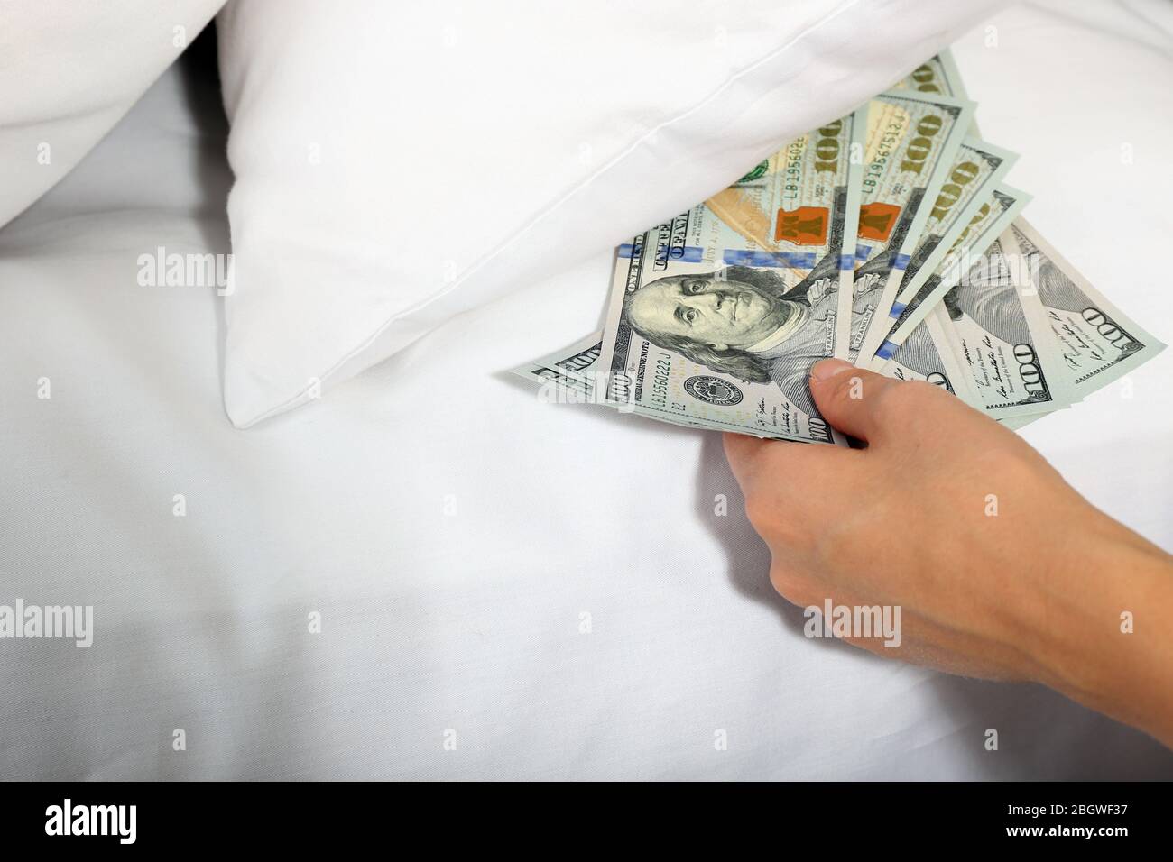 Donna nascondere i soldi sotto il cuscino a casa Foto stock - Alamy