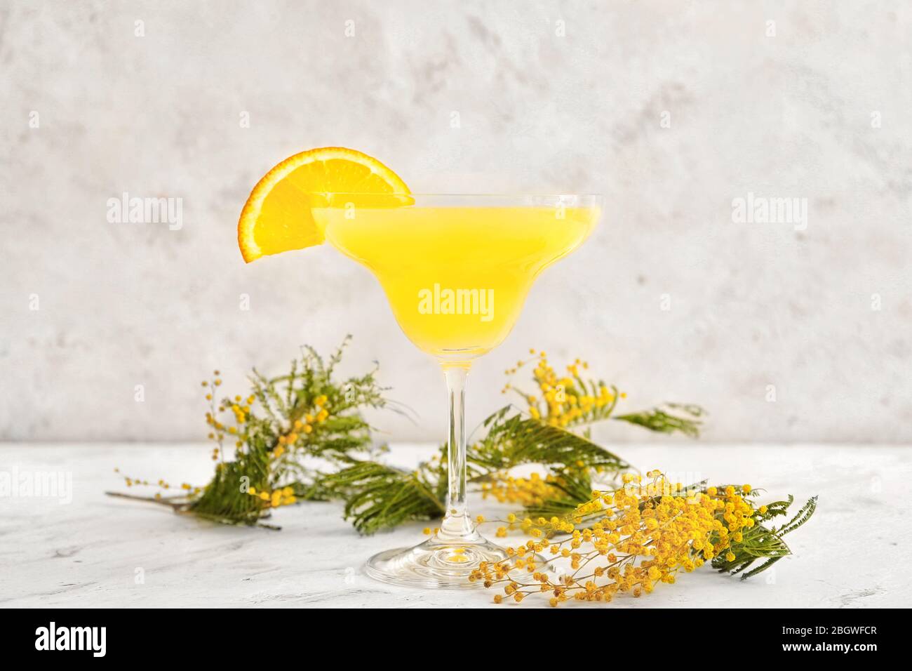 Bicchiere di gustoso cocktail mimosa su sfondo bianco Foto Stock