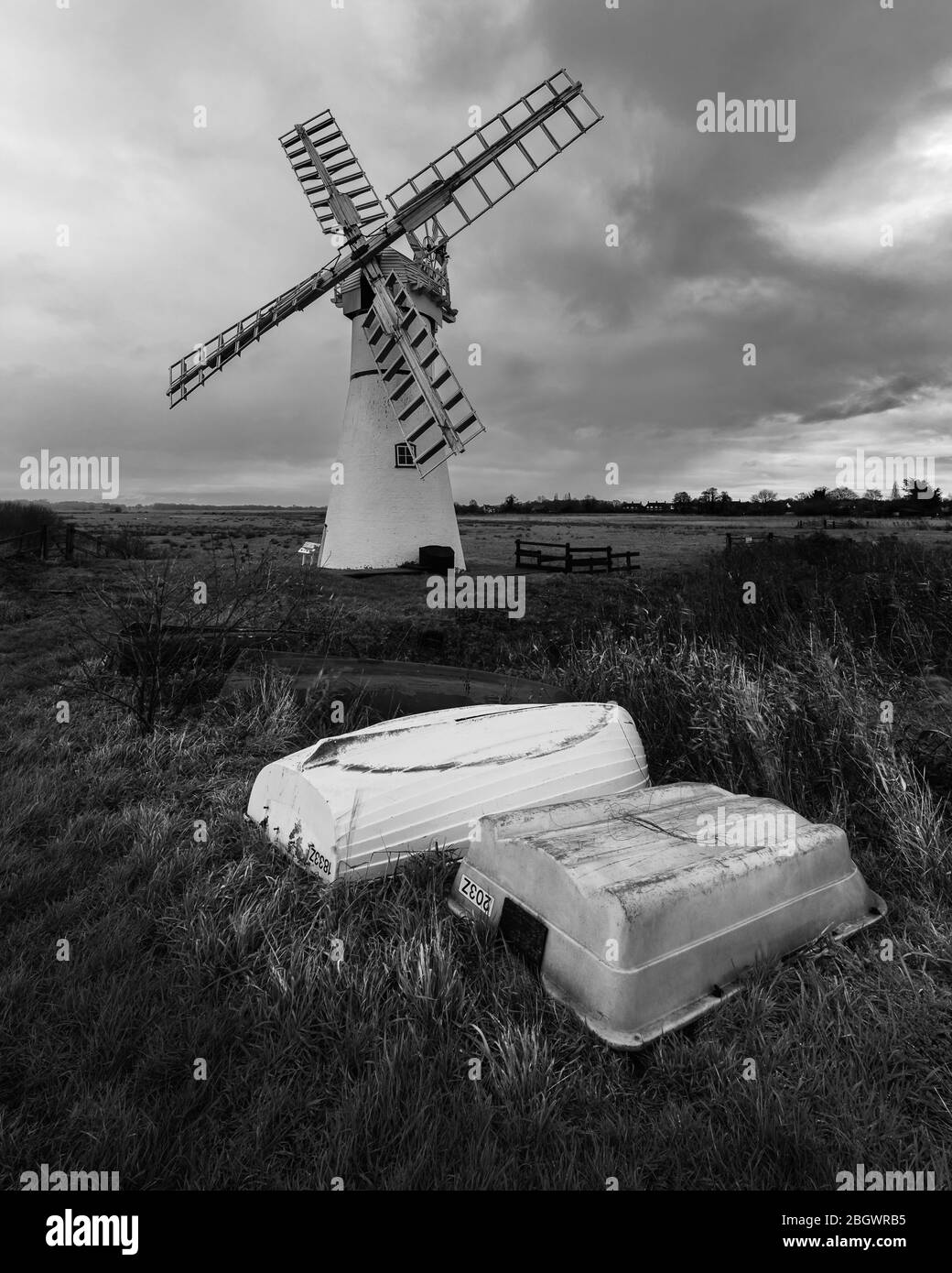 Norfolk winpump mono con barche a remi capovolta fg. Thurne Mill, dicembre 2019 Foto Stock