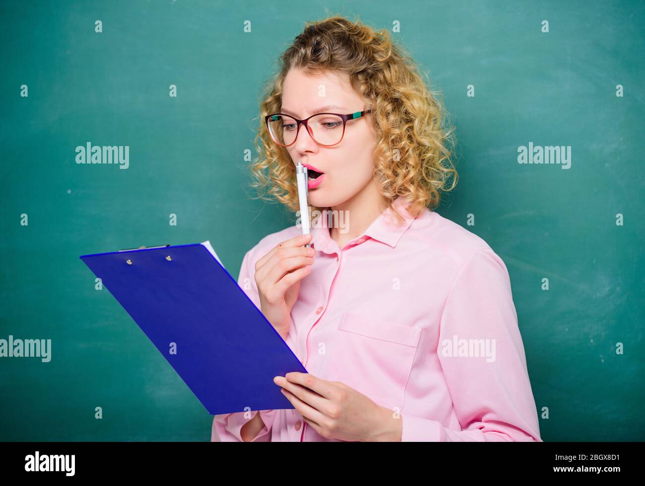 L'insegnante di letteratura ha letto la composizione. Leggere il ripristino con l'impressione. Progetto scolastico. Il tutor controlla le esercitazioni. Donna intelligente donna tenere documenti tablet. Leggi il profilo personale. Saggio di stima dei candidati. Foto Stock