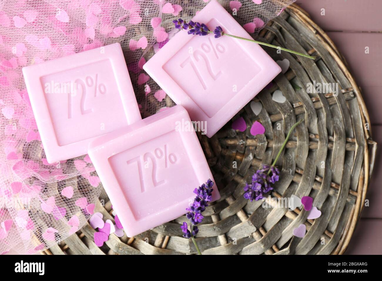 Saponi naturali con lavanda fresca su tappetino in vimini, su sfondo in legno Foto Stock