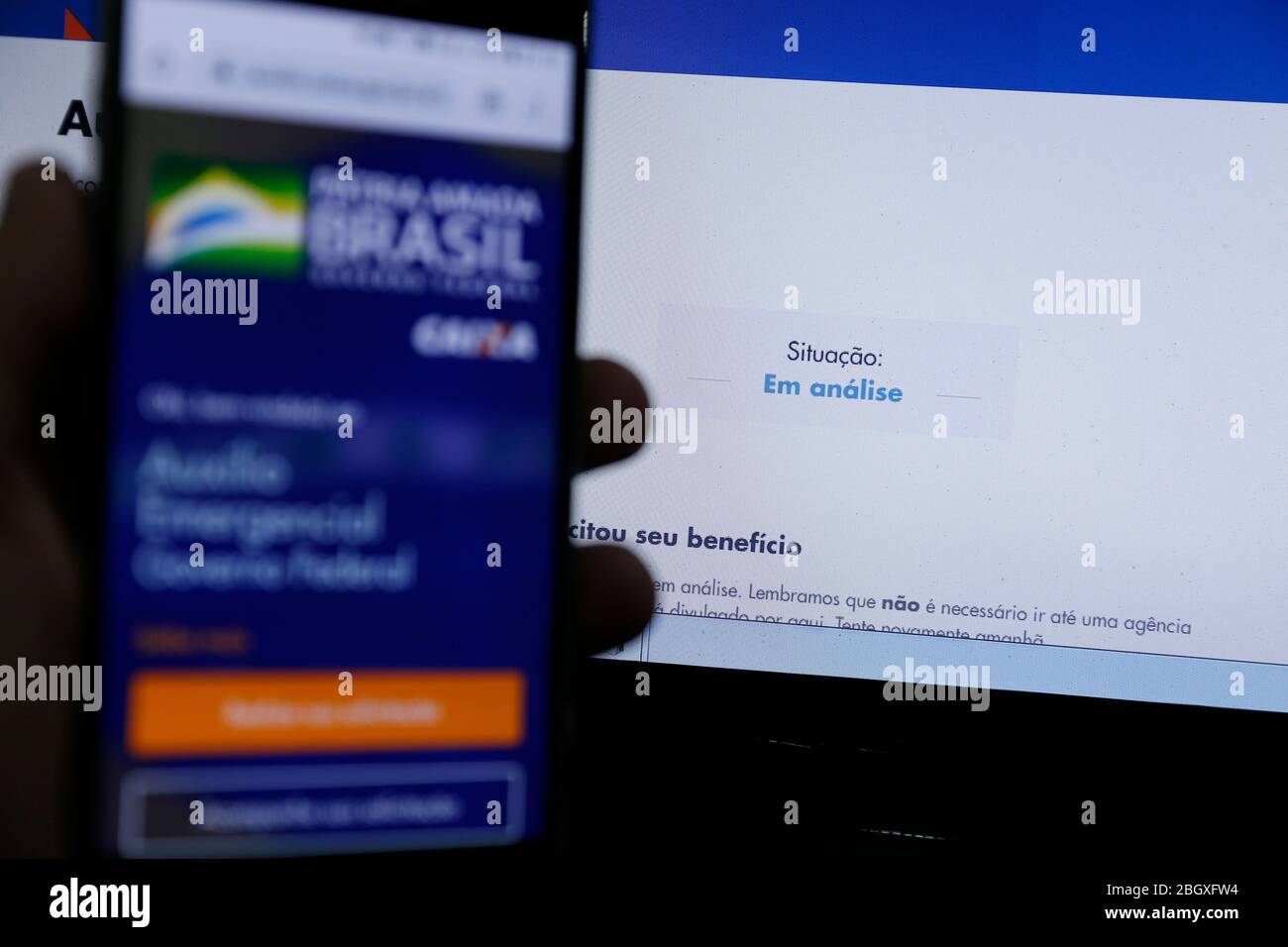 Minas Gerais, MG / Brasile - 22 aprile 2020: Schermo del computer e telefono cellulare con aiuto di emergenza pagina del governo del Brasile, in esame. Foto Stock
