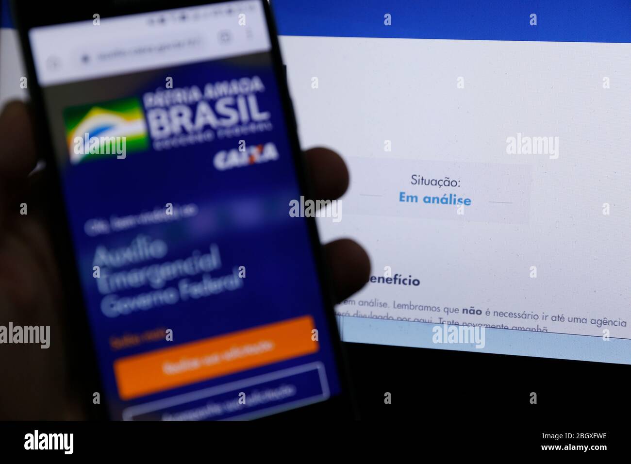 Minas Gerais, MG / Brasile - 22 aprile 2020: Schermo del computer e telefono cellulare con aiuto di emergenza pagina del governo del Brasile, in esame. Foto Stock