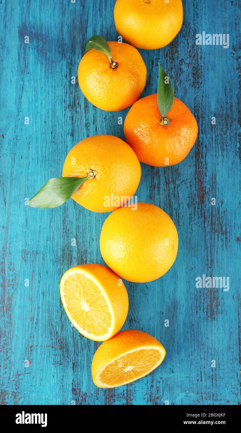 Tangerini maturi e arance con foglie su sfondo ligneo Foto Stock