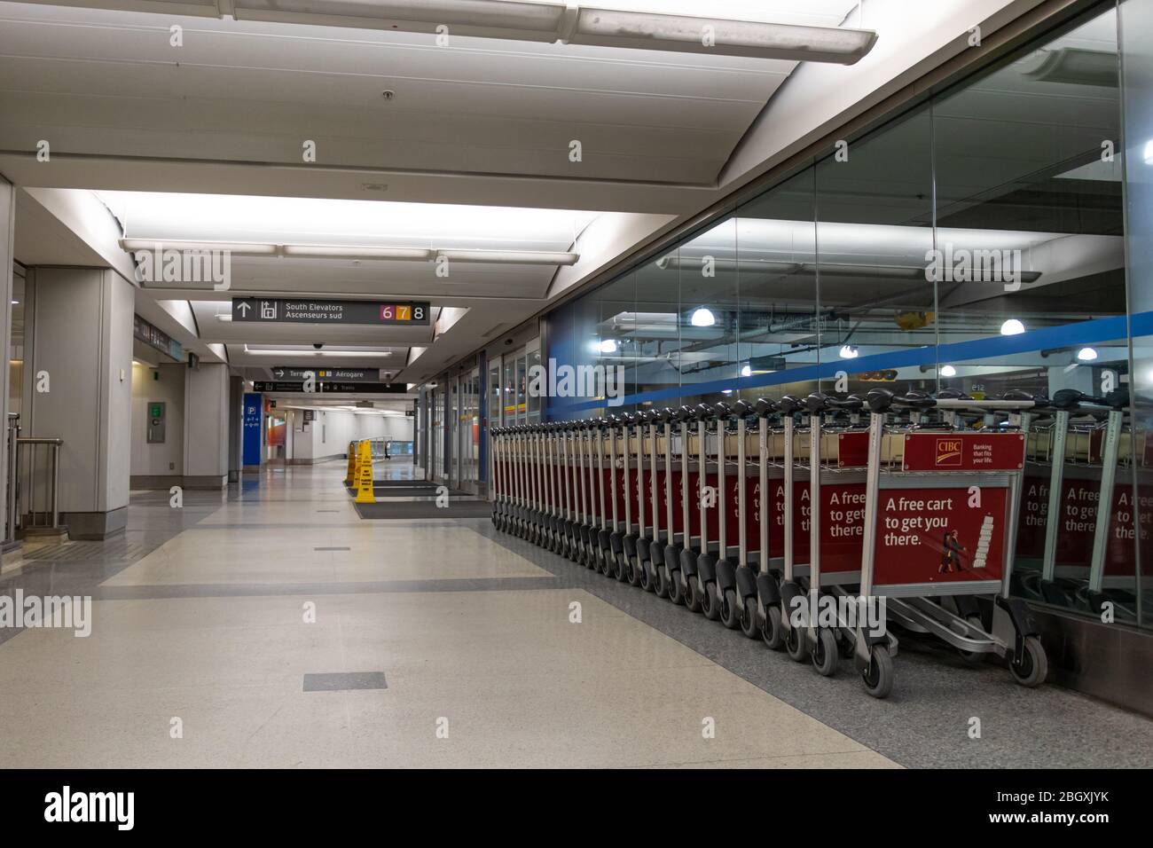 I carrelli per bagagli all'interno di un tunnel del terminal vuoto all'esterno di un garage all'Aeroporto Internazionale Pearson di Toronto. Foto Stock