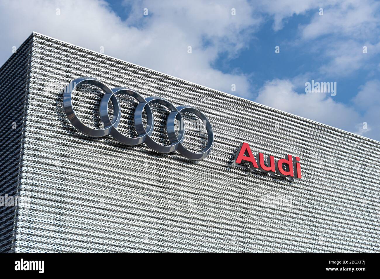 Logo Audi Four-ring e testo all'esterno di una concessionaria Audi. Foto Stock