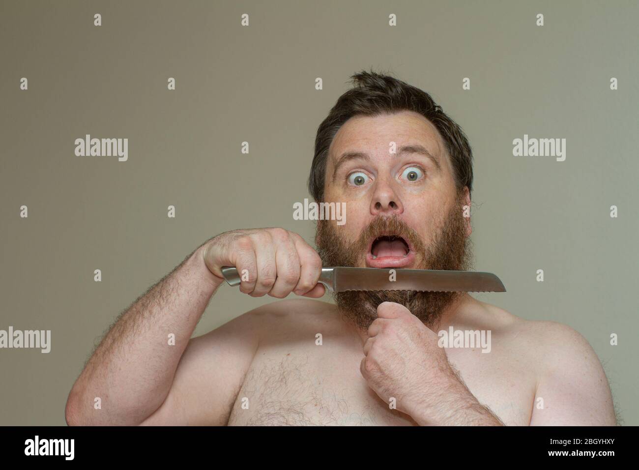 Uomo che taglia i capelli con un coltello affilato Foto Stock