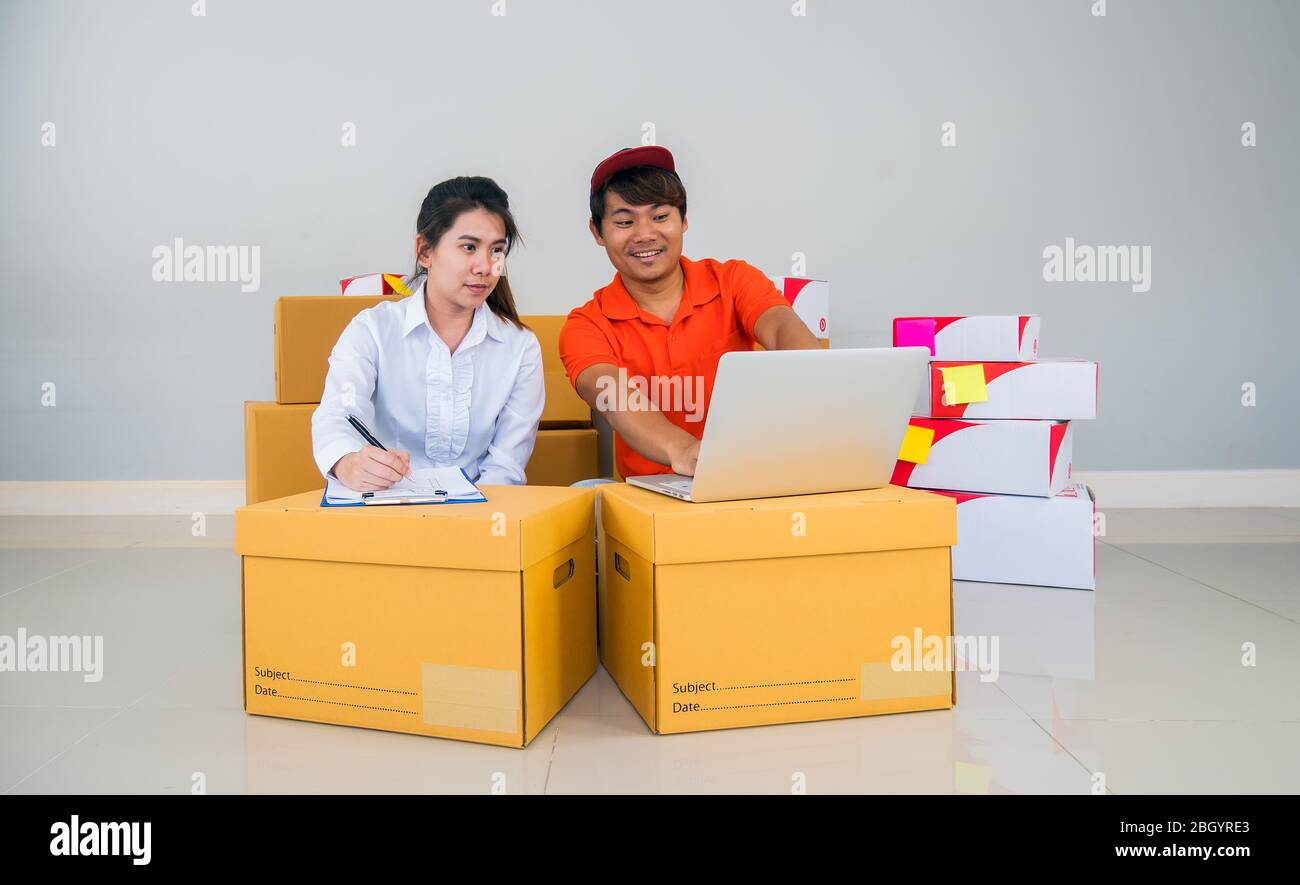 Team di Start up proprietario piccola impresa con molti pacchetti di pacchi stanno controllando l'ordine di articoli da clienti che ordinano online prima di spedizione con Check list Foto Stock