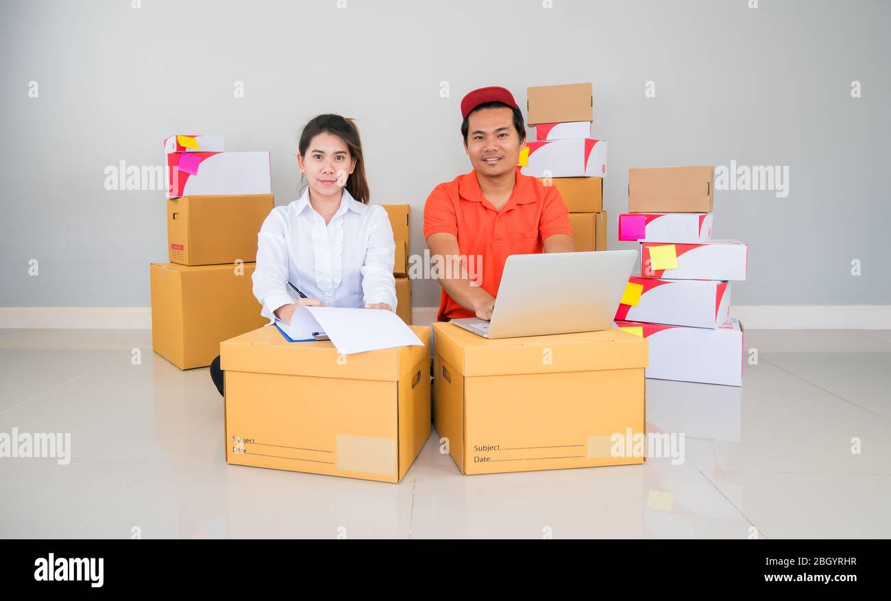 Team di Start up proprietario piccola impresa con molti pacchetti di pacchi stanno controllando l'ordine di articoli da clienti che ordinano online prima di spedizione con Check list Foto Stock