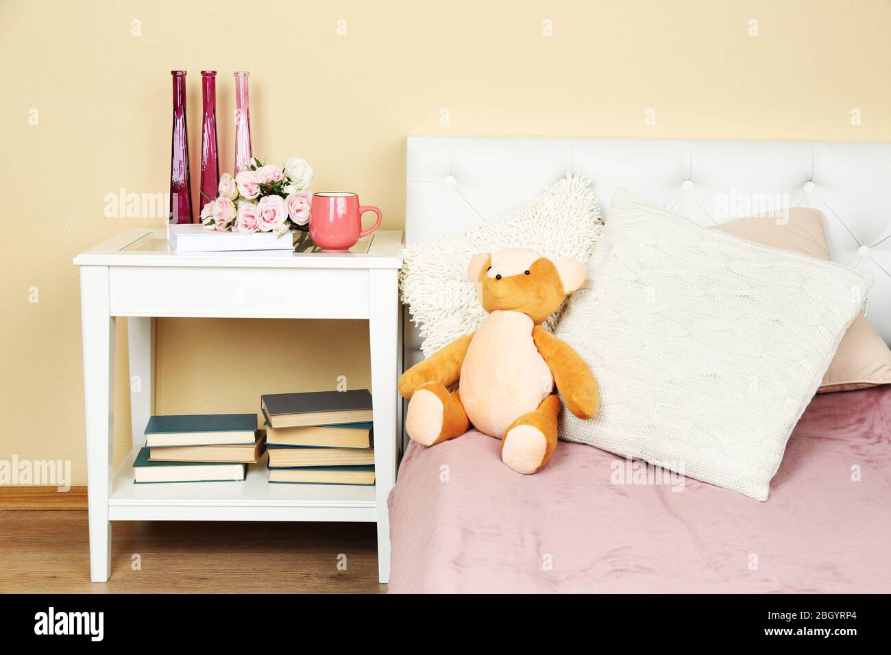 Interni moderni e colorati con letto e comodino, con dettagli di design su sfondo chiaro Foto Stock