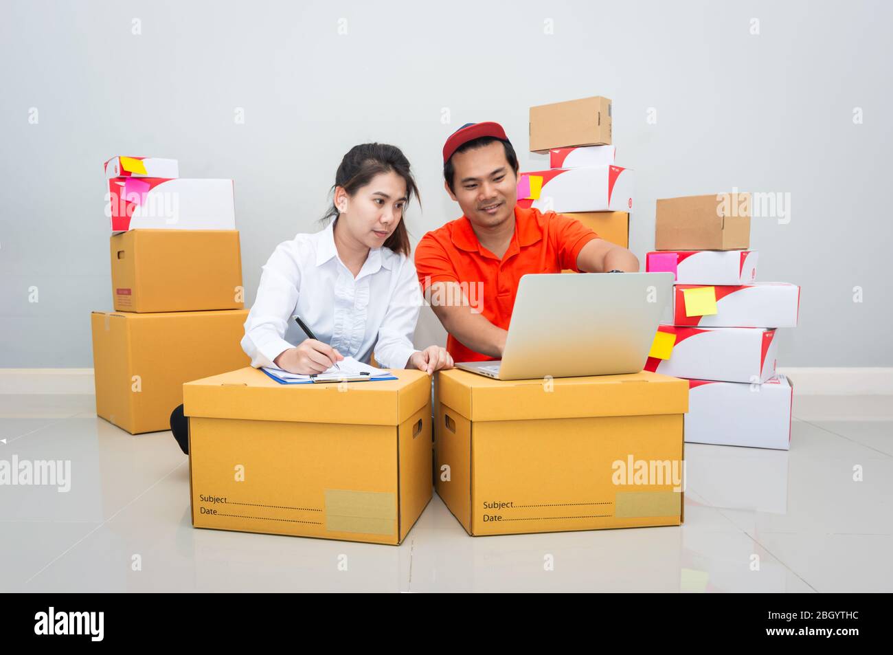 Team di Start up proprietario piccola impresa con molti pacchetti di pacchi stanno controllando l'ordine di articoli da clienti che ordinano online prima di spedizione con Check list Foto Stock