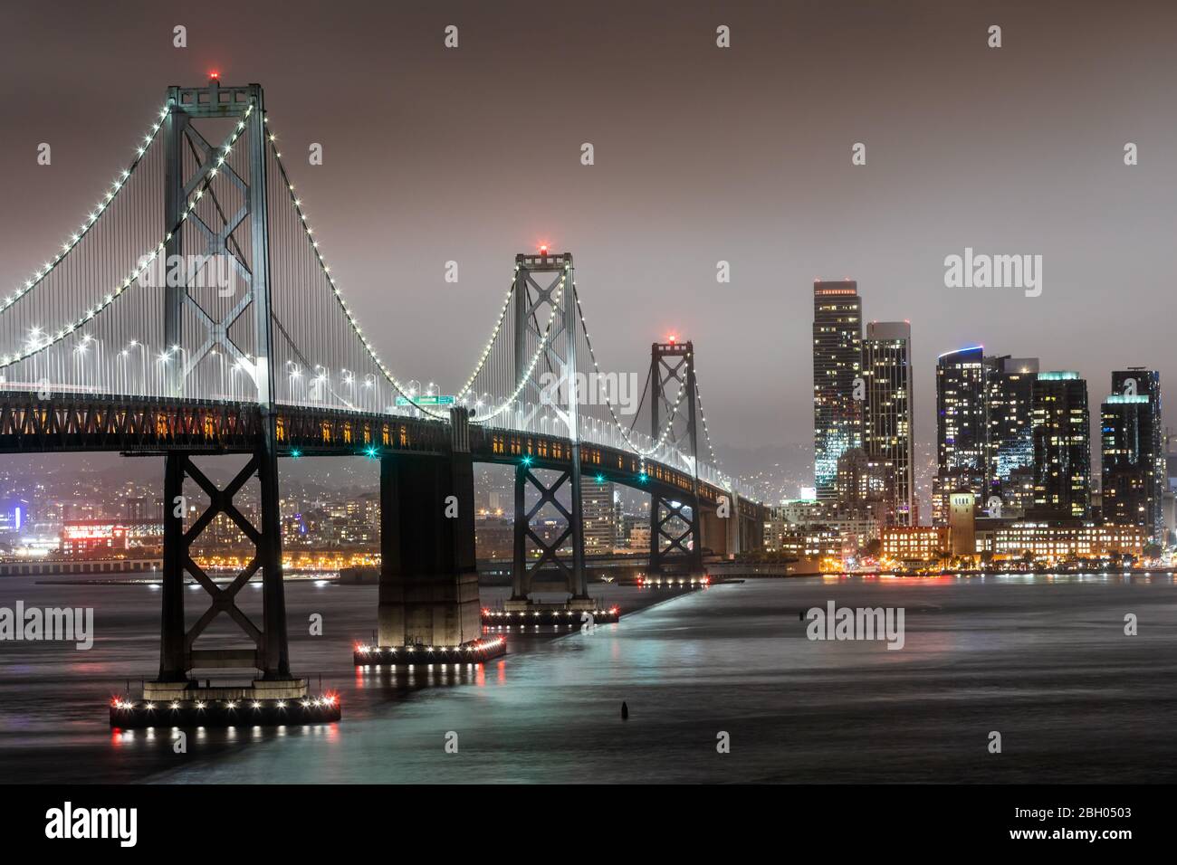 Foto notturna del Bay Bridge e del San Skyline di Francisco Foto Stock