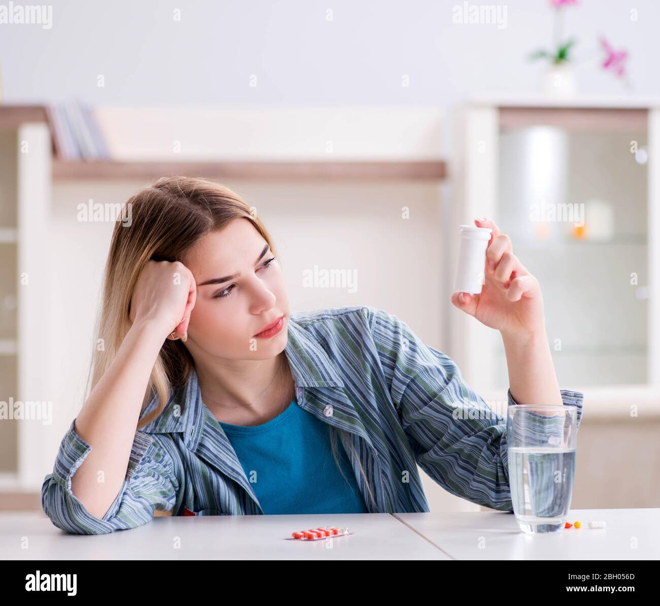 La donna di prendere le pillole per affrontare il dolore Foto Stock