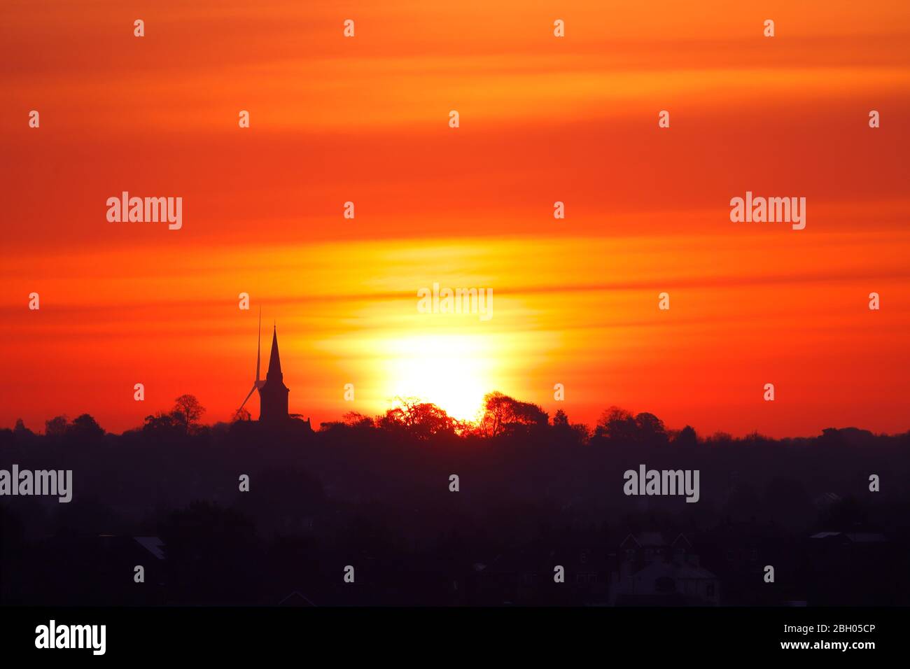 Una bella alba su Garforth a Leeds. Hook Moor Wind Farm & St Mary's Church si distinguono sopra l'orizzonte Foto Stock