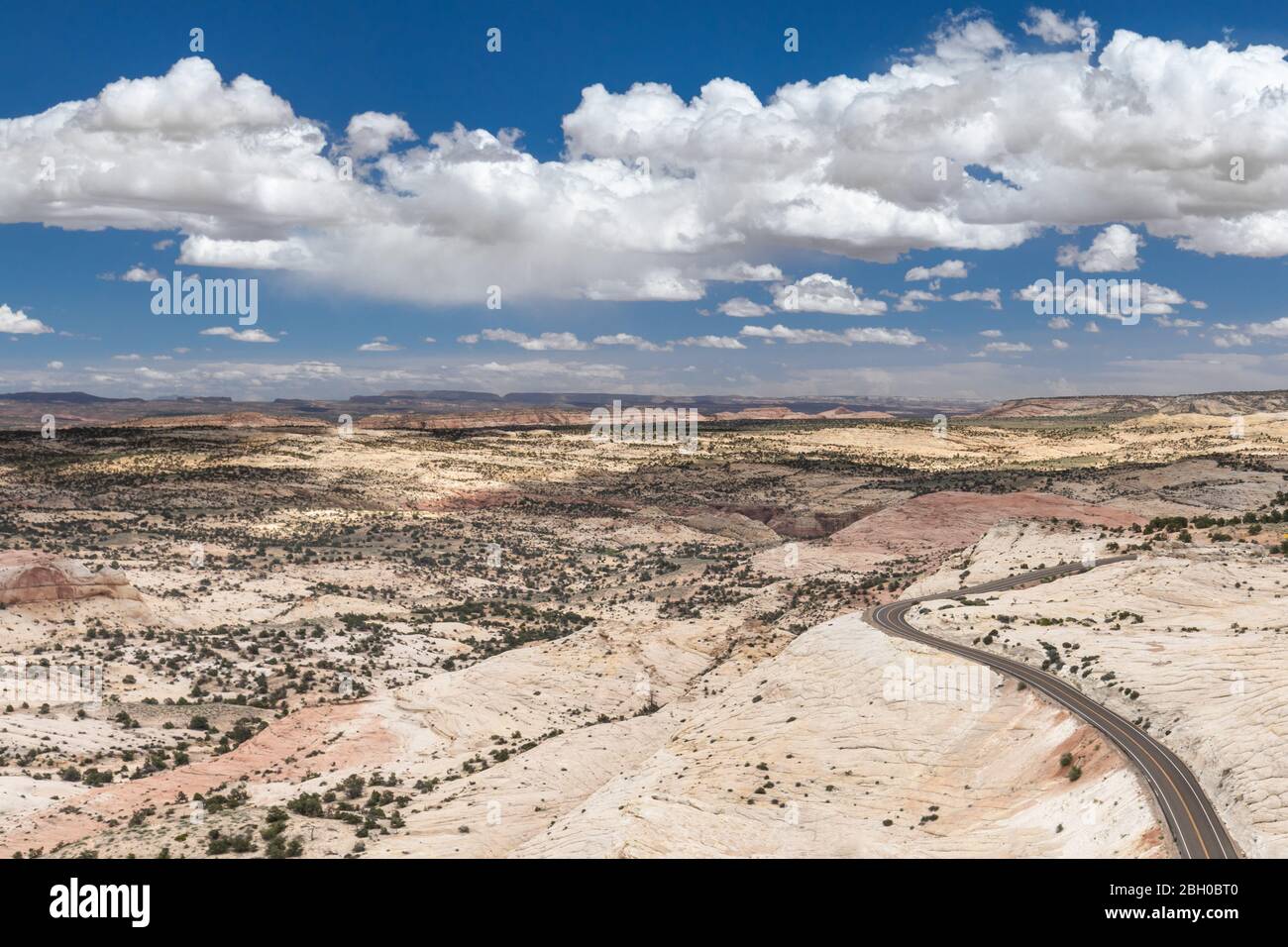 In Utah, un paesaggio desertico, sotto un cielo blu con nuvole soffici, è attraversato da Scenic Byway 12 Foto Stock