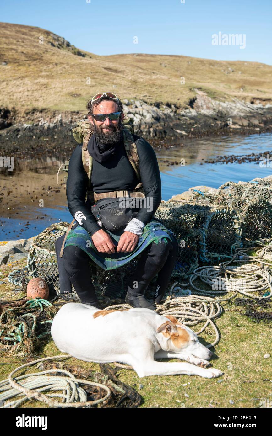 Hildasay, Shetland, Scozia, UK , 22 aprile 2020, ex-Paratrooper e camminatore di beneficenza Chris Lewis e il suo compagno Jet sull'isola di Hildasay, sulla costa occidentale di Shetland, erano auto-isolanti durante la pandemia COVID-19. Chris è in una passeggiata benefica lungo la costa del Regno Unito, che ha iniziato nel 2017. Tutto il denaro raccolto va verso la beneficenza delle forze armate SSAFA. L'isola di Hildasay è un'isola non abitata e Chris e Jet sono gli unici occupanti durante questa tme. Foto:Dave Donaldson Credit: Dave Donaldson/Alamy Live News Foto Stock