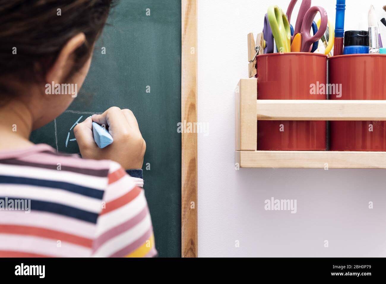 disegno bambino irriconoscibile su una lavagna, disegno e concetto artigianale a casa Foto Stock