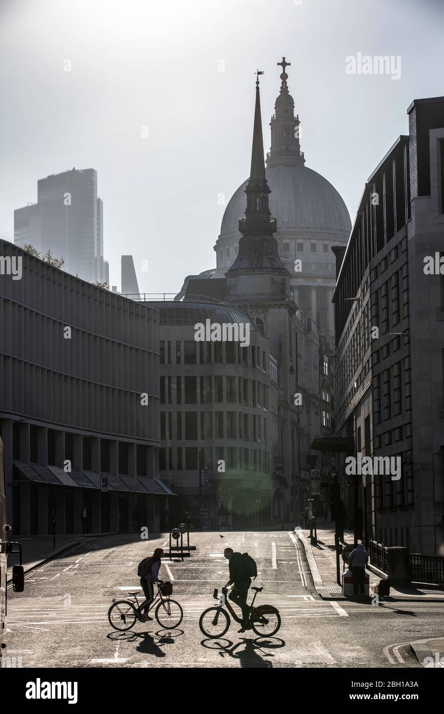 Londra, Regno Unito. 23 aprile 2020. Una rara vista di ciclisti commuter attraverso Ludgate Circus questa mattina, sotto lo skyline della cattedrale di St Paul nella City of London, poiché le misure di blocco devono essere alleggerite nelle prossime tre o quattro settimane in mezzo al coronavirus affinché l'economia possa riprendersi. City of London Lockdown, England, United Kingdom 23 Aprile 2020 Credit: Jeff Gilbert/Alamy Live News Foto Stock