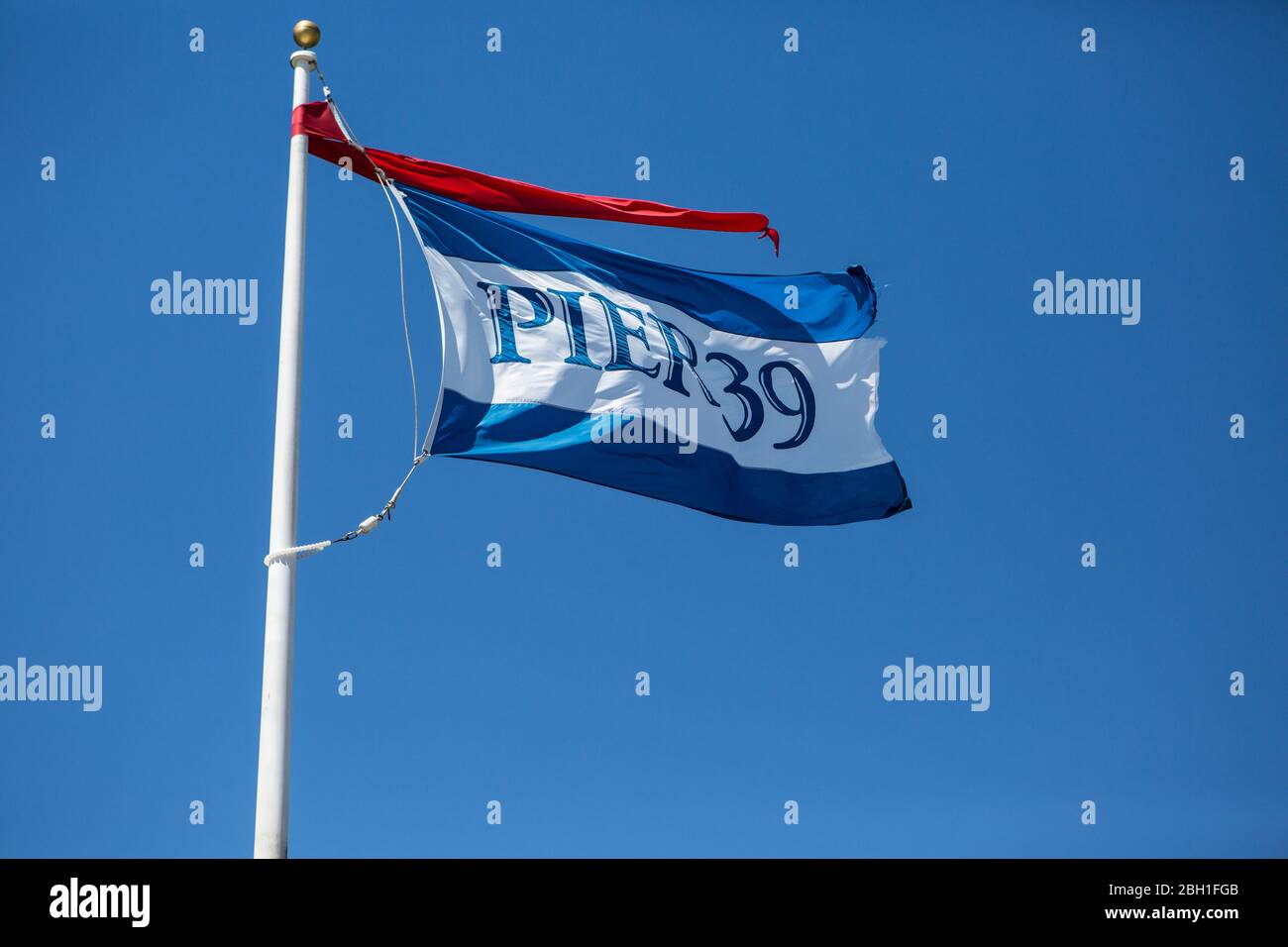 Molo 39 bandiera che vola nel vento contro un cielo azzurro Foto Stock