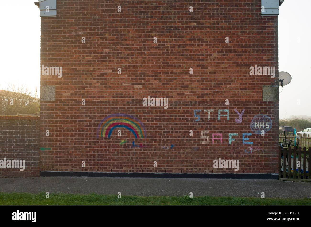 Chalk scritto su un muro di casa in Inghilterra circa NHS Stay Safe Coronavirus Covid-19 Foto Stock