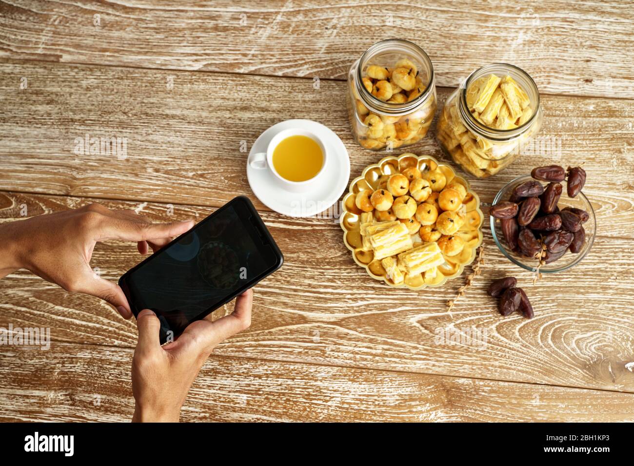 gesto di mano con il telefono cellulare scattando foto di tradizionale spuntino indonesiano Foto Stock