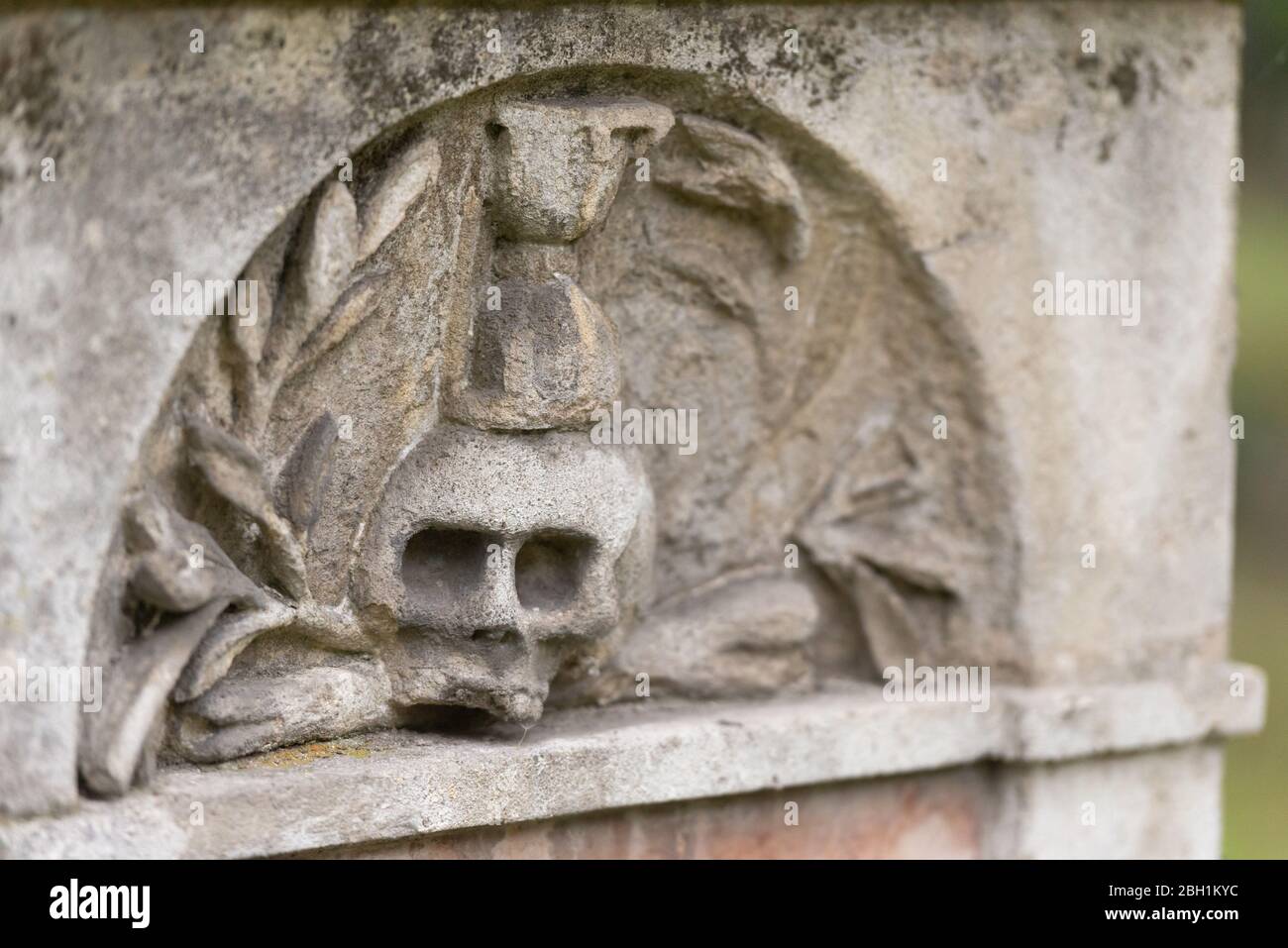 Vecchio cimitero nel centro di Bratislava. Il monumento è coperto di muschio. Il cranio sul monumento, su una delle tombe. Foto Stock