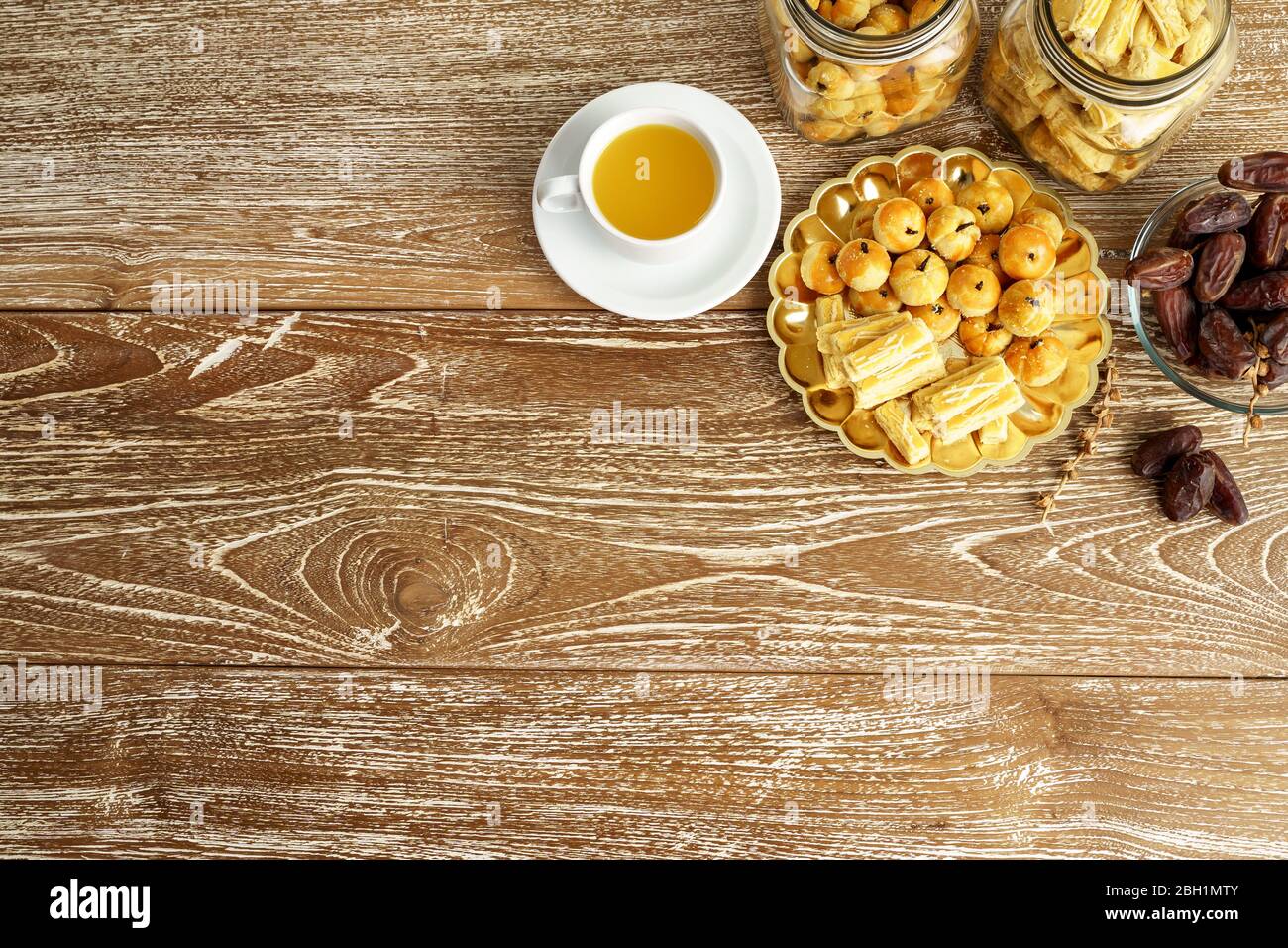 immagine di uno spuntino per rompere il veloce. tradizionale spuntino islamico nastar asiatico servito con tè su sfondo di legno Foto Stock