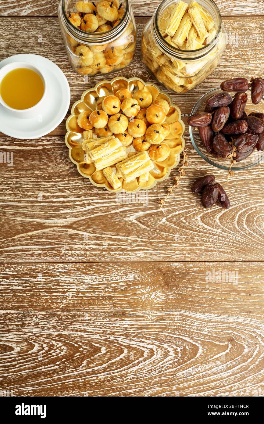 immagine di uno spuntino per rompere il veloce. tradizionale spuntino islamico nastar asiatico servito con tè su sfondo di legno Foto Stock