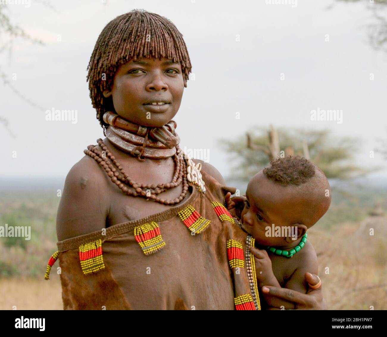 Hamer Tribeswoman tiene il suo bambino. Fotografato nella Valle del fiume Omo, Etiopia Foto Stock