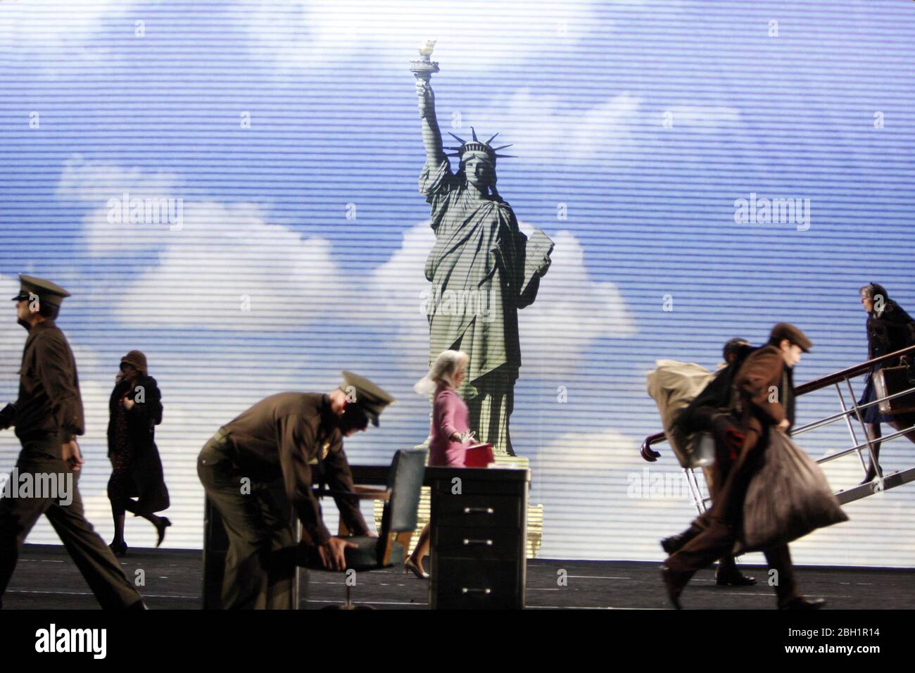 Gli immigrati arrivano a Ellis Island a CANDIDE una produzione inglese di Opera Nazionale (ENO) al London Coliseum nel 2008 musica: Leonard Bernstein lyrics: Richard Wilbur, Stephen Sondheim, John Latouche, Lillian Hellman, Dorothy Parker & Leonard Bernstein libro adattato da Voltaire da Hugh Wheeler liberamente adattato da Robert Carsen & Ian Burton Set design: Michael Levine Costumi: Buki Shiff illuminazione: Robert Carsen & Peter Van Praet coreografia : Rob Ashford regista: Gli immigrati Robert Carsen arrivano a Ellis Island English National Opera (ENO) / London Coliseum WC2 25/06/2008 Foto Stock