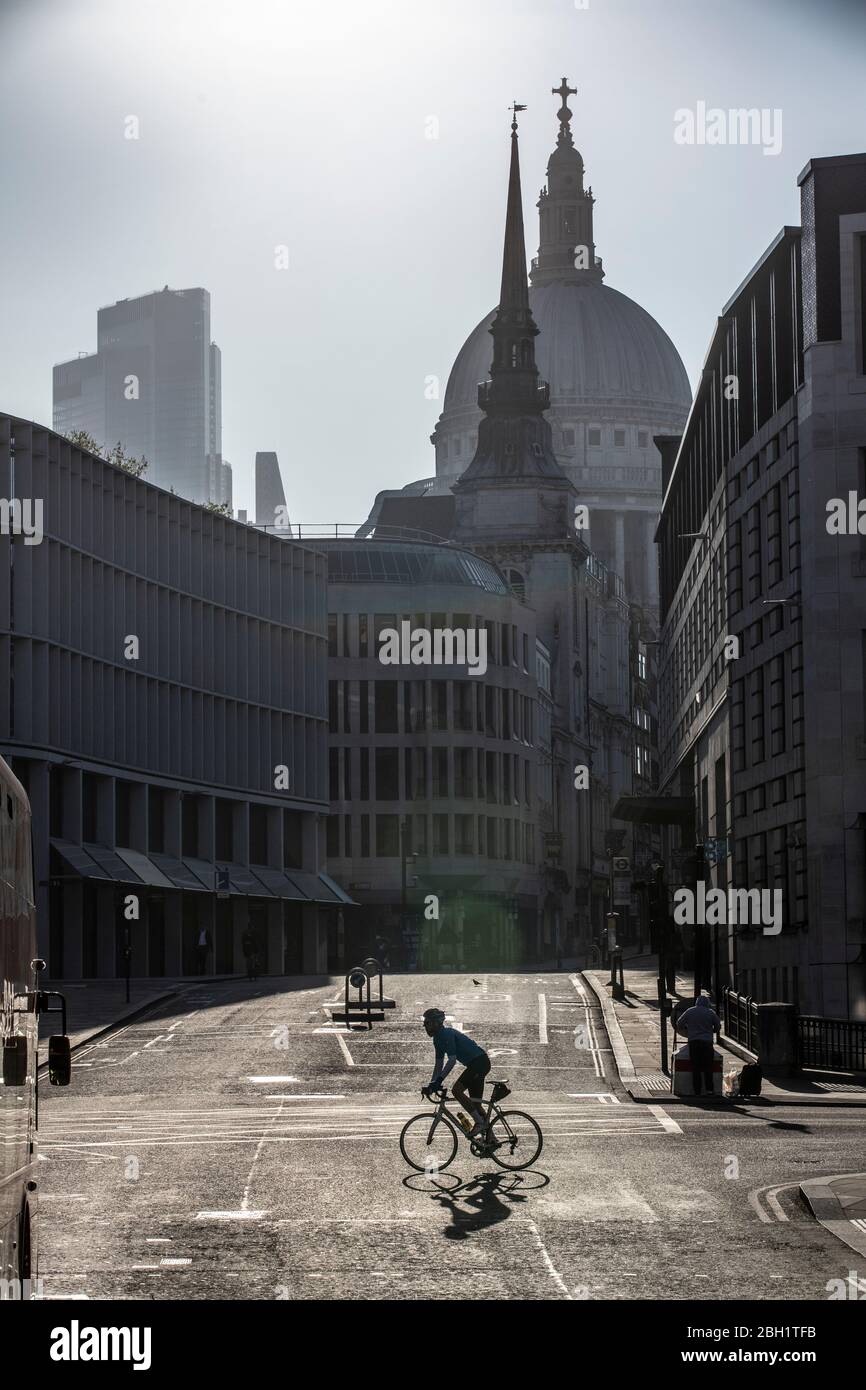 Un pendolari soleggiato attraversa Ludgate Circus all'inizio di questa mattina sotto lo skyline della cattedrale di St Paul nella City of London, poiché le misure di blocco devono essere alleggerite nelle prossime tre o quattro settimane in mezzo al coronavirus affinché l'economia possa riprendersi. City of London Lockdown, England, United Kingdom 23 Aprile 2020 Credit: Jeff Gilbert/Alamy Live News Foto Stock