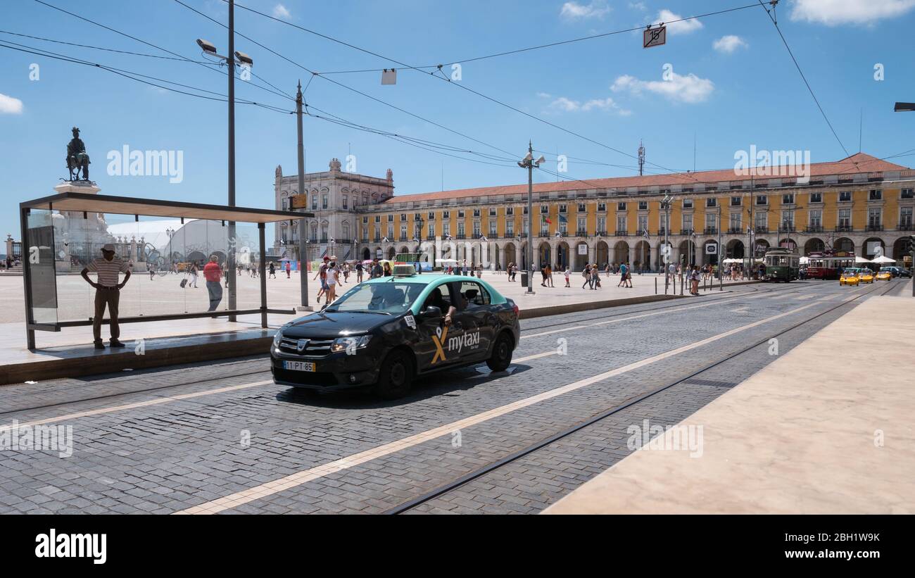 Un taxi commerciale MyTaxi sulle strade della posizione turistica centrale di Lisbona, la Piazza Comercio in una giornata estiva luminosa e soleggiata in Portogallo. Foto Stock