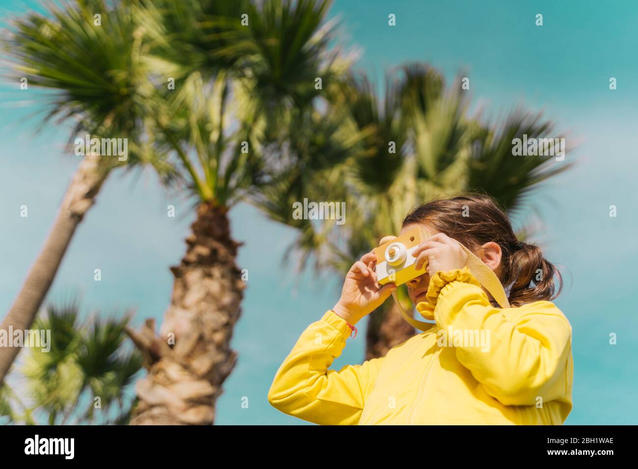 Bambina che scatta foto con la macchina fotografica giocattolo Foto Stock