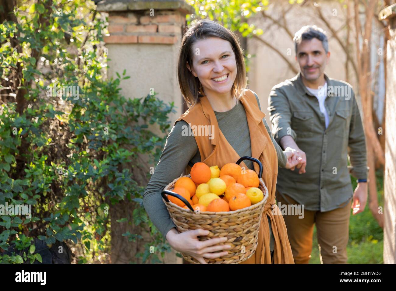 Coppia felice che tiene un cestino con limoni e arance Foto Stock