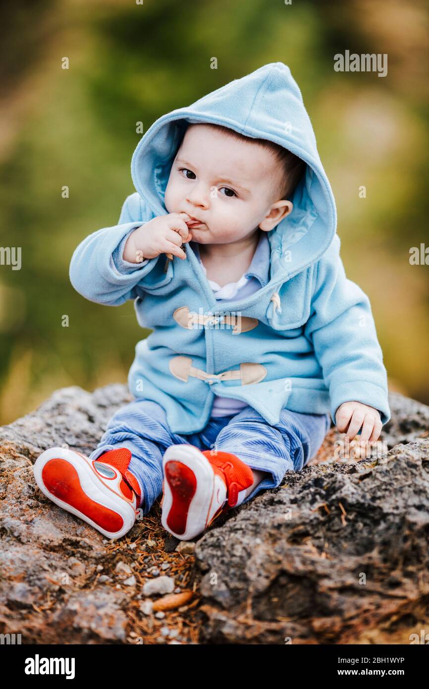 Ritratto del bambino che indossa una giacca con cappuccio blu chiaro all'aperto Foto Stock